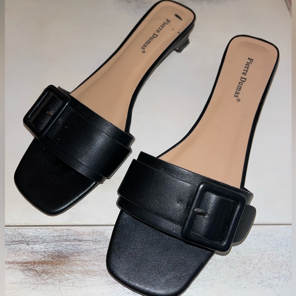 Black slides w/ buckle accent. Preloved w/ small chunky rectangular heel. Sz 7.5